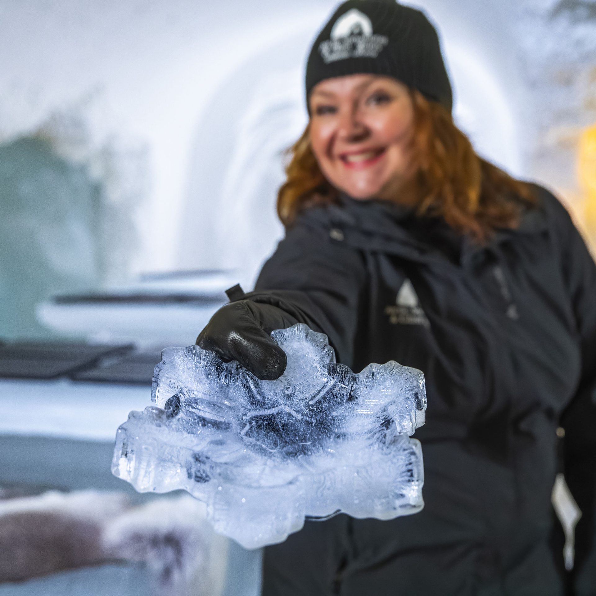 Tarjoilija ojentaa jäästä valmistettua lumihiutaleen mallista tarjouilulautasta.