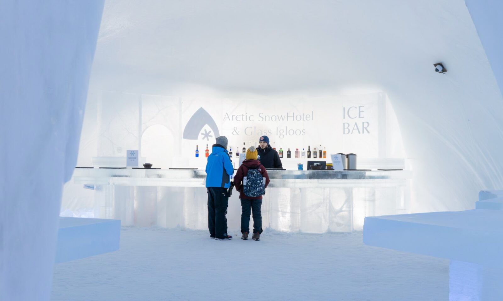 Guests at the Ice Bar made of snow and ice at Arctic SnowHotel & Glass Igloos.
