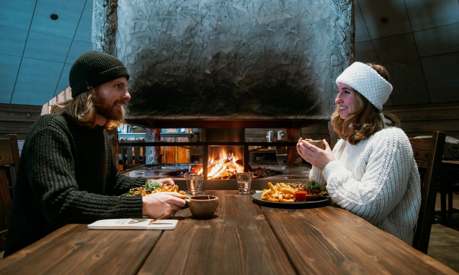 Guests dining by the fireplace at Arctic SnowHotel & Glass Igloos.