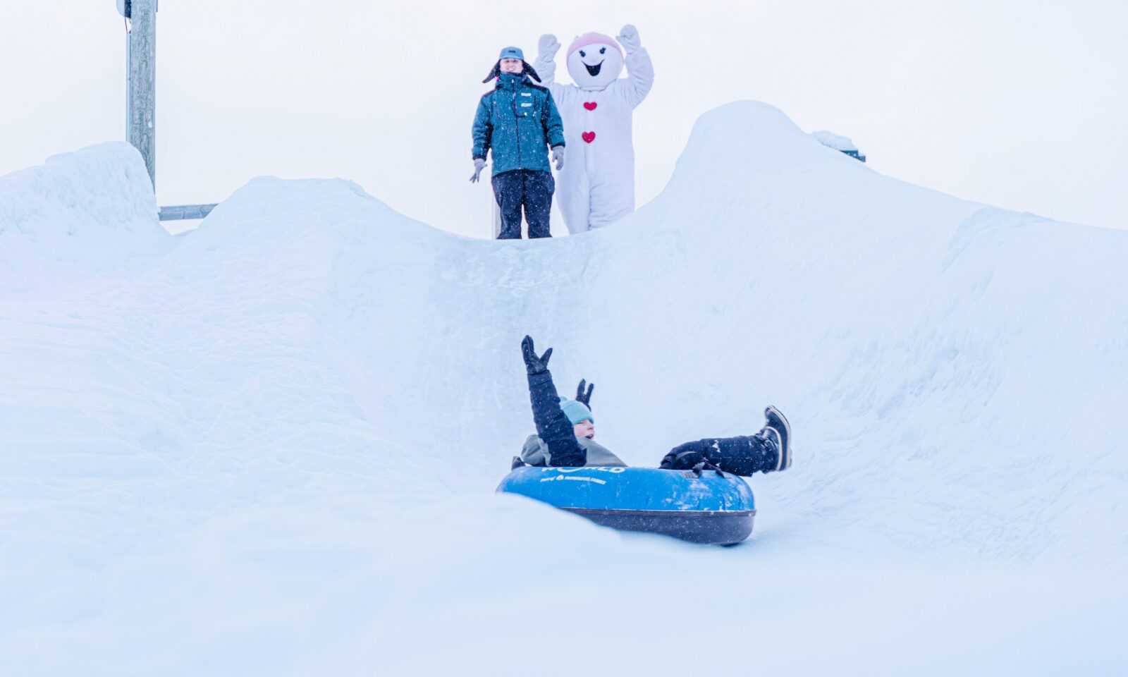 Lapsi laskee lumiliukumäkeä Snowman Worldissa.