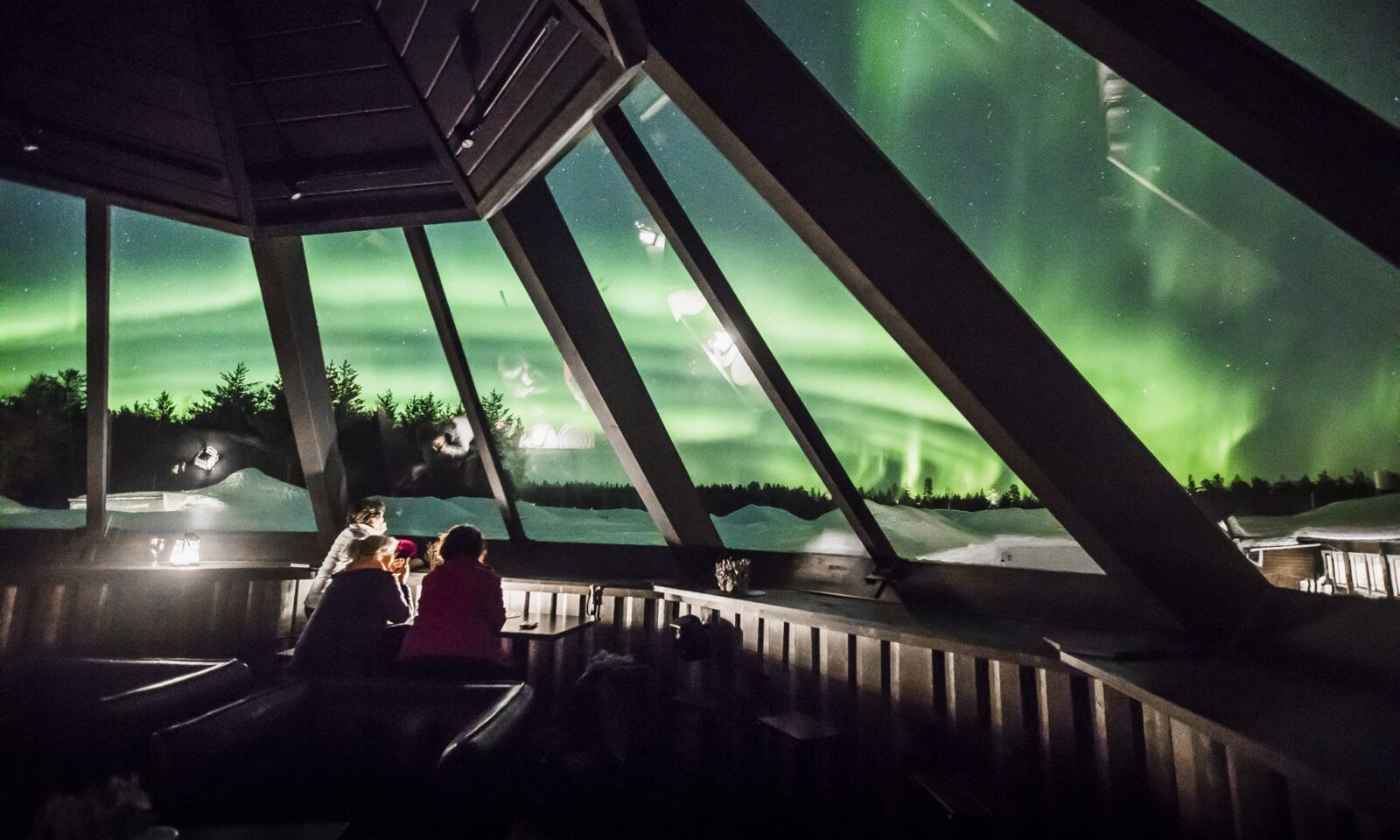 Northern Lights viewed through the glass roof of Sky Bar at Arctic SnowHotel & Glass Igloos.