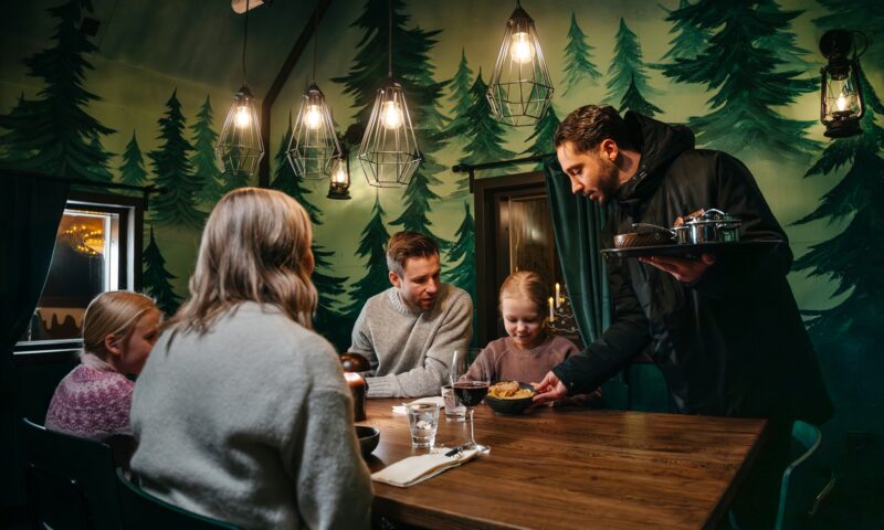 Guests dining in a private gingerbread cabin at Piparina in Santa Claus Village.