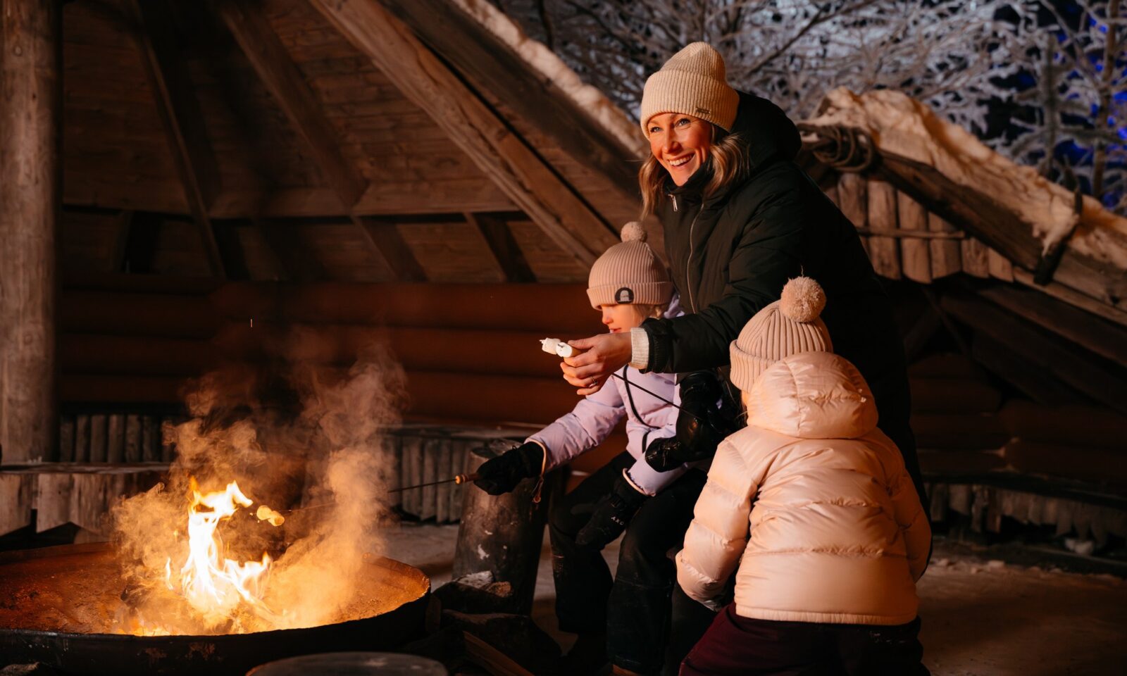 Family roasting marshmallows by the fireplace at Piparina.